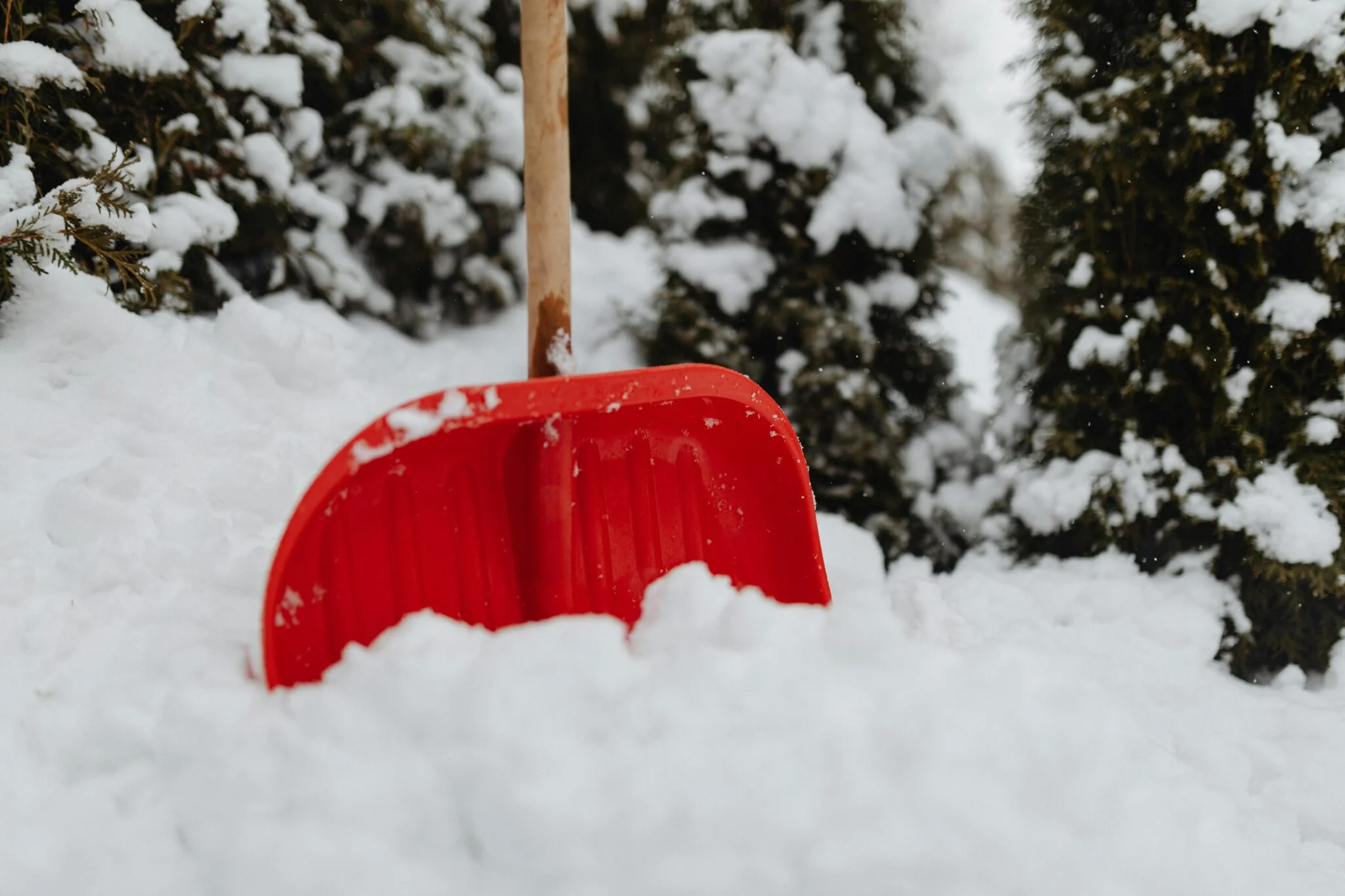 Röd snöskyffel i kraftigt snöfall för snöskottning i Umeå